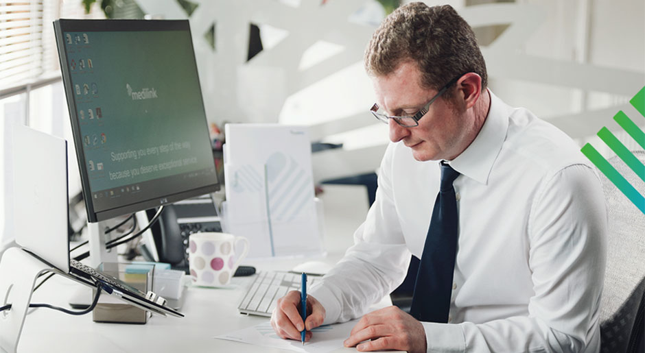 Man sat at desk writing