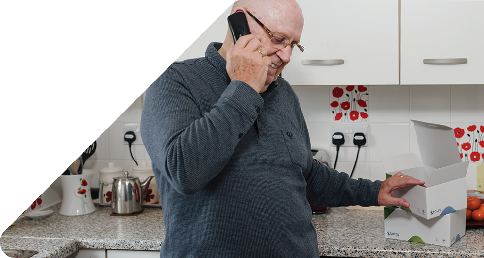 Man on phone in his kitchen with Medilink product